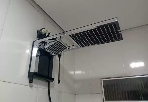 Lorenzetti Acqua Duo preto e cromado, visto de lado instalado em parede branca